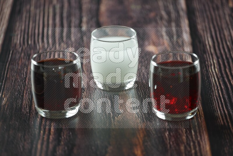 Cold drinks in a glass cup such as water, tamarind, qamar eldin, sobia, milk and hibiscus on wooden background