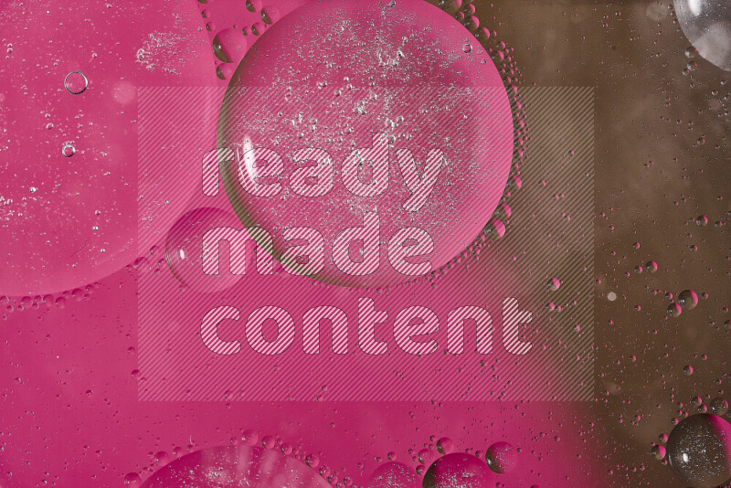 لقطات مقربة لفقاعات من الزيت على سطح الماء باللون الوردي والبني