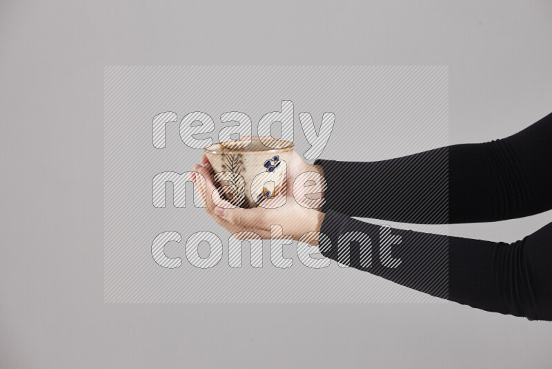 A woman in black abaya holding different pottery essentials in different positions