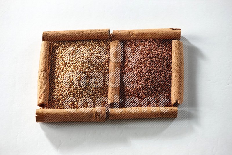 2 squares of cinnamon sticks full of mustard seeds and garden cress on white flooring