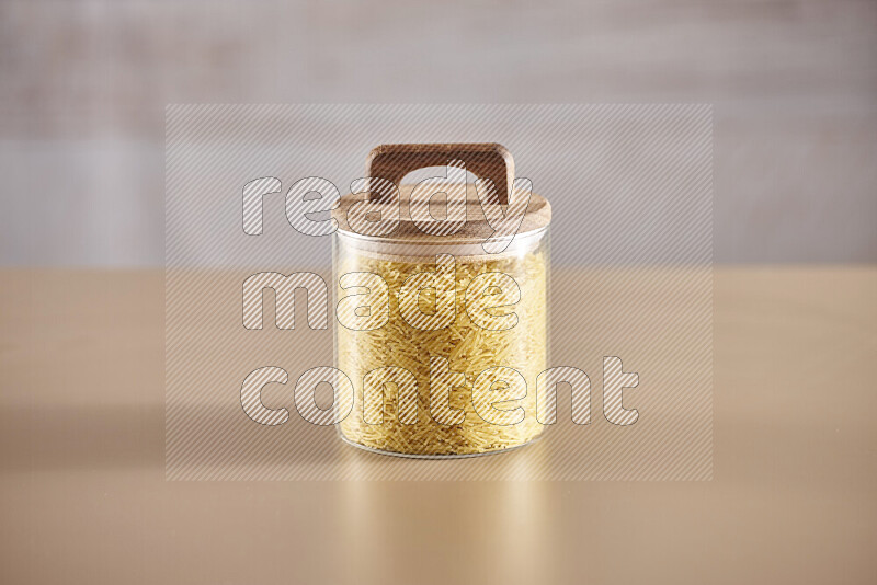 Raw pasta in glass jars on beige background