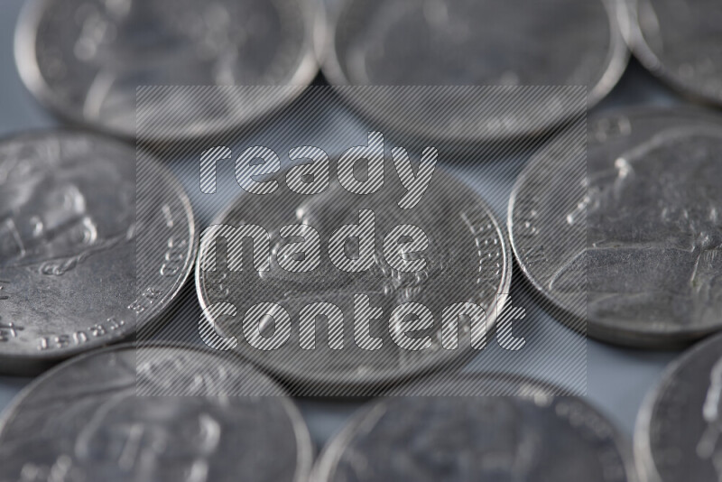 A close-up of scattered United States one dime coins on grey background