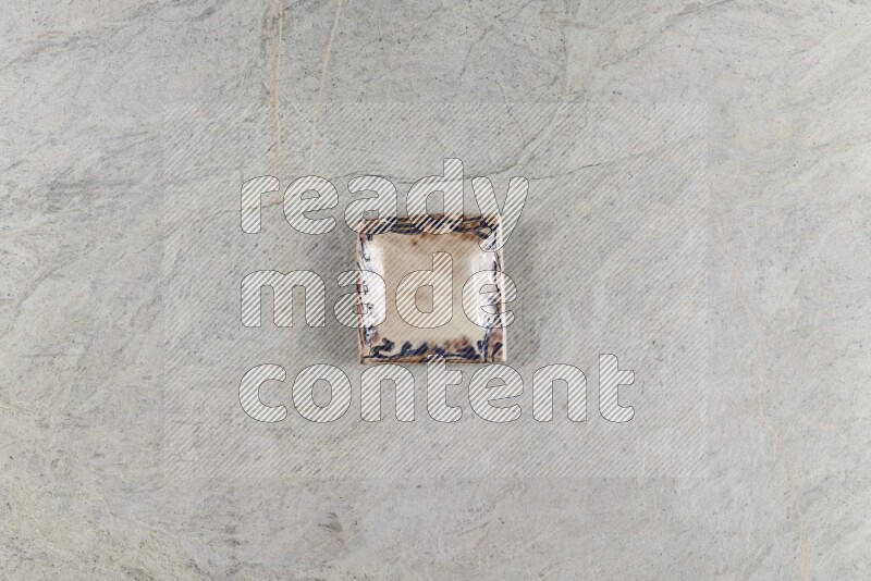 A decorative pottery plate on grey marble background