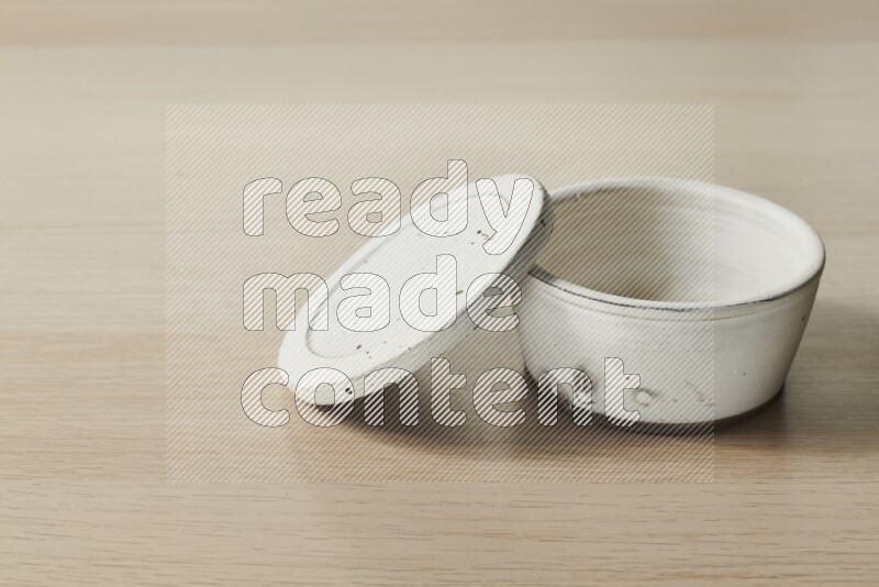 A white pottery bowl on light wooden background