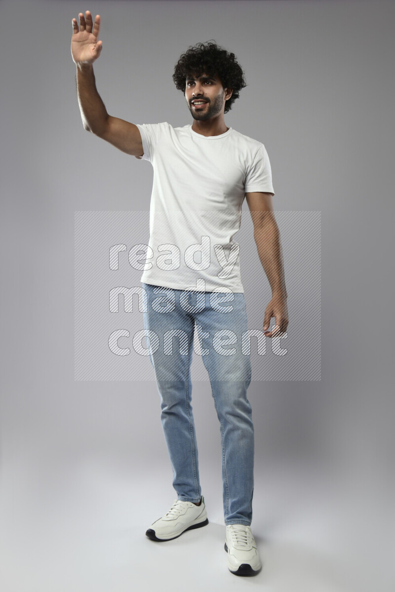 A man wearing casual standing and making a hand gesture on white background
