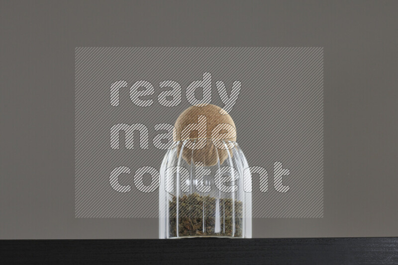 Dried basil in a glass jar on black background