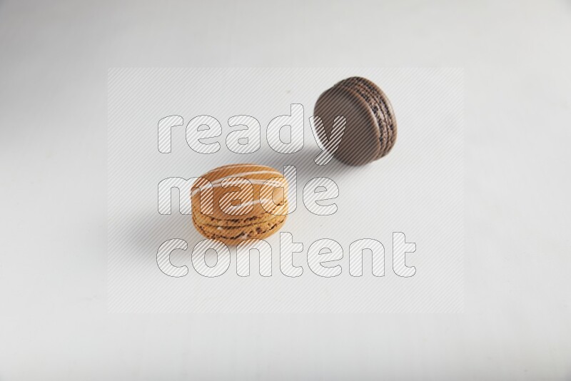 45º Shot of of two assorted Brown Irish Cream, and Brown Dark Chocolate macarons on white background