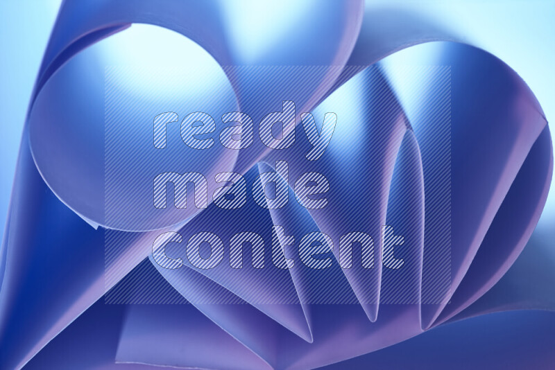 عرض فني لطيات الورق تخلق مزيج من الأشكال الهندسية، مضاءة بإضاءة ناعمة بدرجات اللون الأزرق والوردي