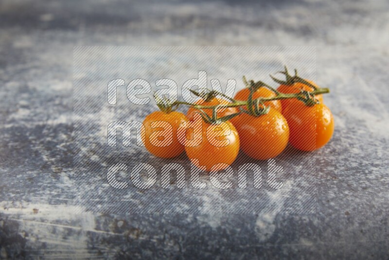 Orange cherry tomato vein on a textured rusty blue background 45 degree