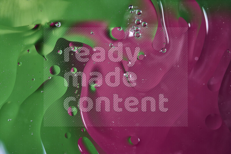 لقطات مقربة لفقاعات من الزيت على سطح الماء باللون الأخضر والوردي