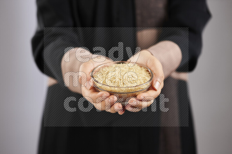 Woman in abaya holding different kinds of legumes in different positions