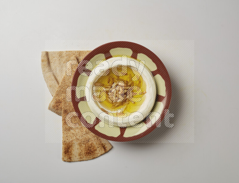 Lebnah garnished with pine nuts in a traditional plate on a white background