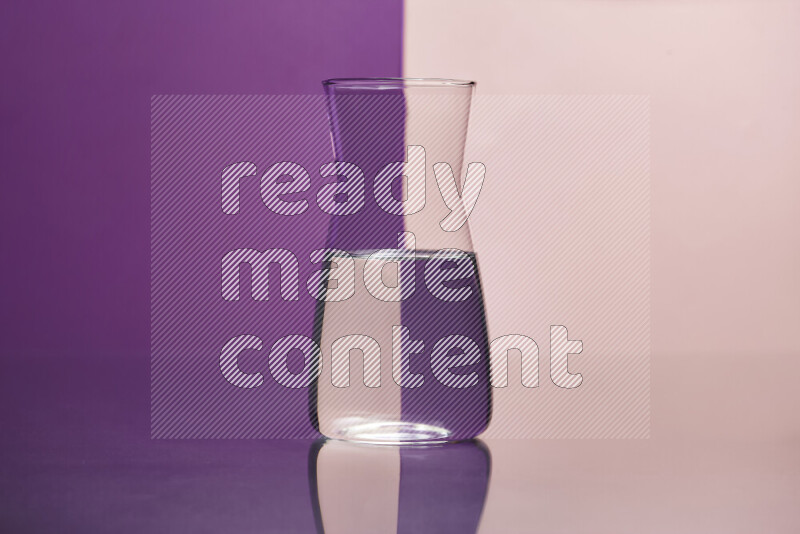 The image features a clear glassware filled with water, set against purple and rose background