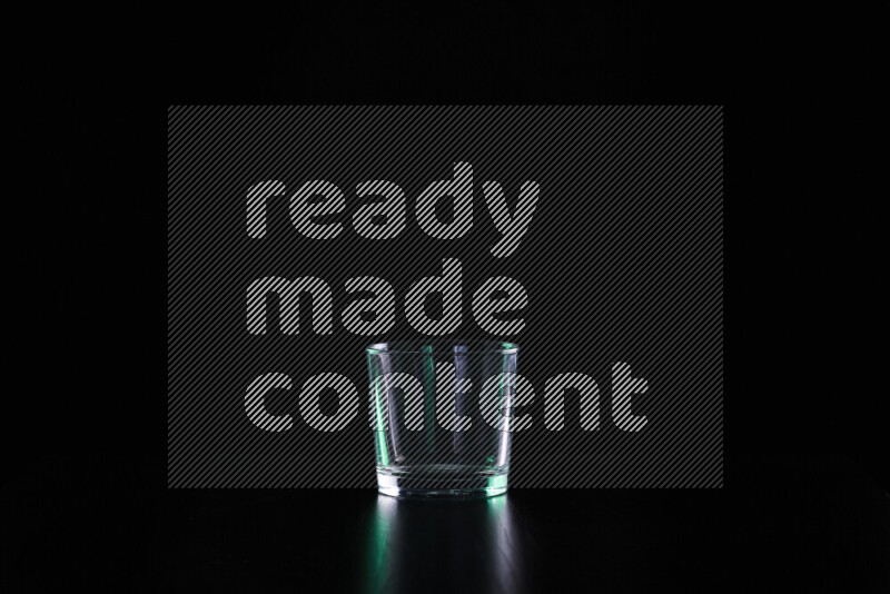 Glassware with rim light in green and white against black background