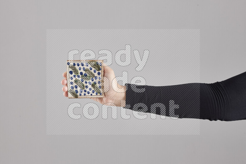 A woman in black abaya holding different pottery essentials in different positions