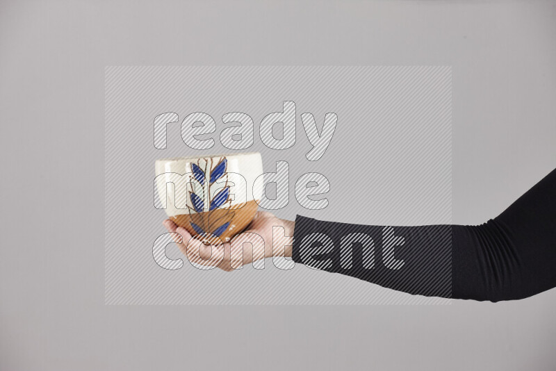 امرأة ترتدي عباءة سوداء تحمل أدوات فخارية مختلفة في أوضاع متعددة