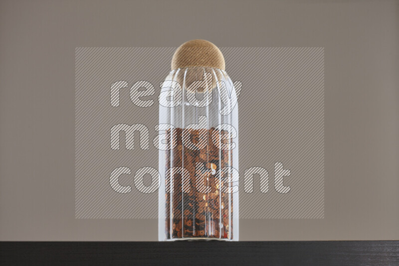 Sequins in a glass jar on black background