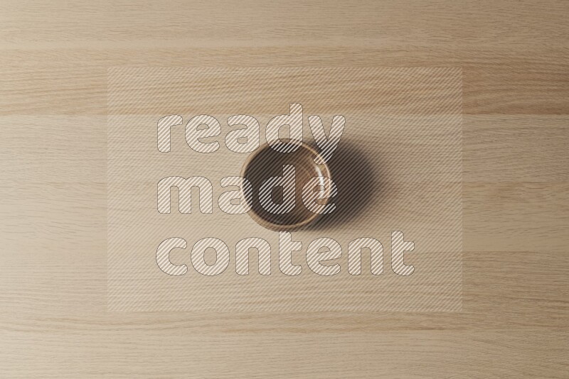 A beige pottery bowl on light wooden background