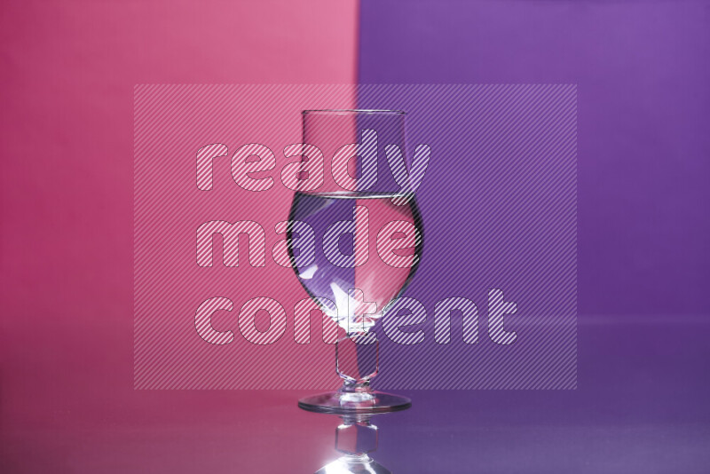 The image features a clear glassware filled with water set against pink and purple background