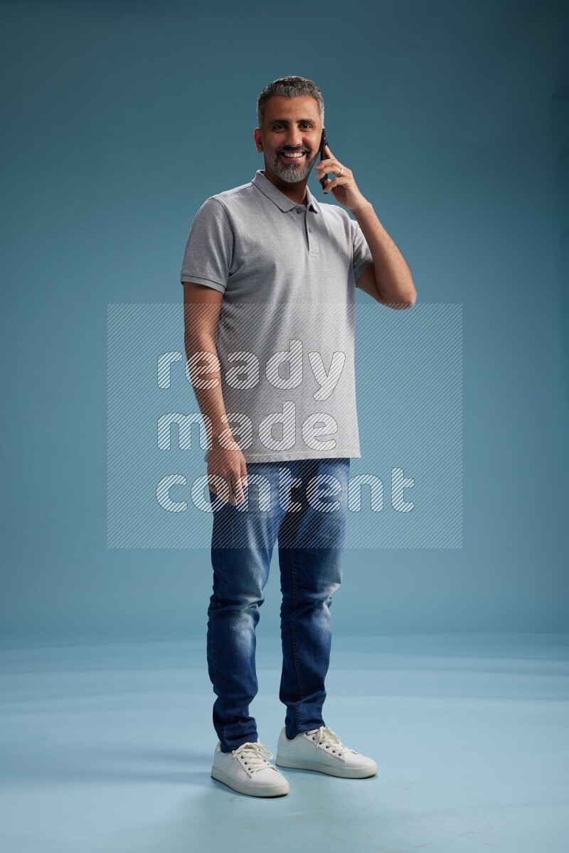 Man Standing talking on phone on blue background