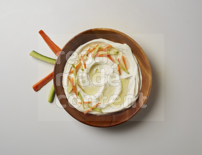 Lebnah garnished with sliced carrots & cucumber in a wooden plate on a white background