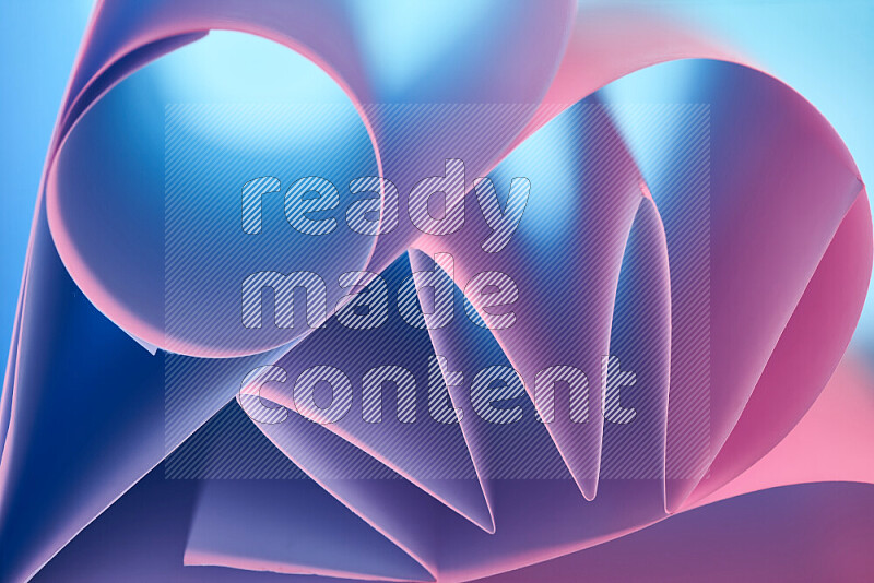 An artistic display of paper folds creating a harmonious blend of geometric shapes, highlighted by soft lighting in blue and pink tones