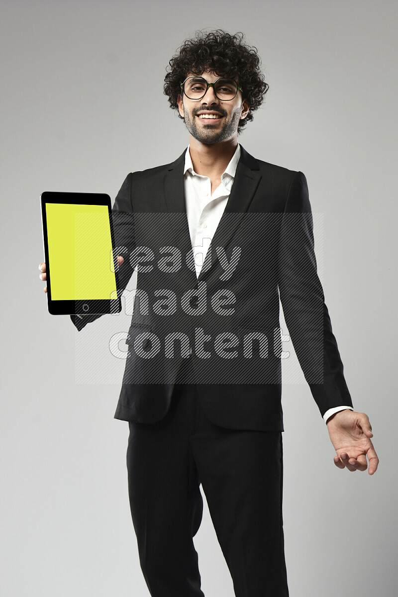 A man wearing formal standing and showing a tablet screen on white background