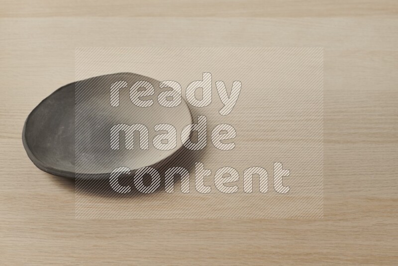 صحن فخاري متعدد الألوان على خلفية خشبية فاتحة