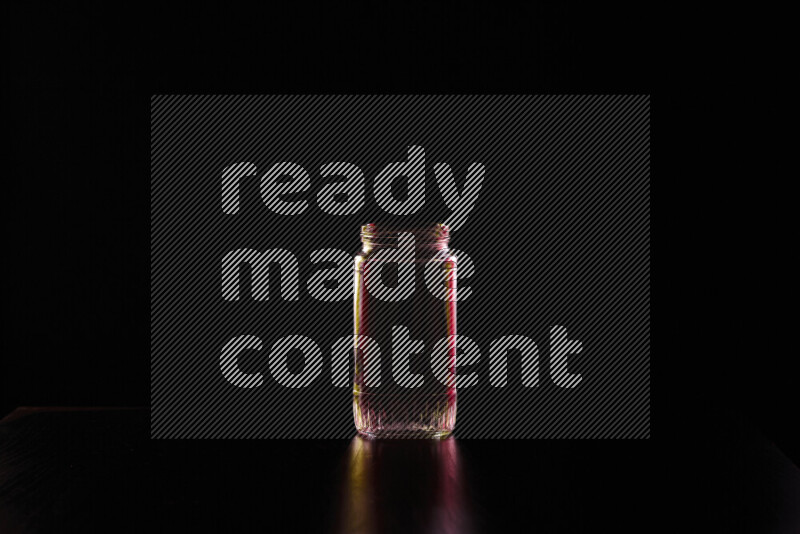 Glassware with rim light in red and yellow against black background