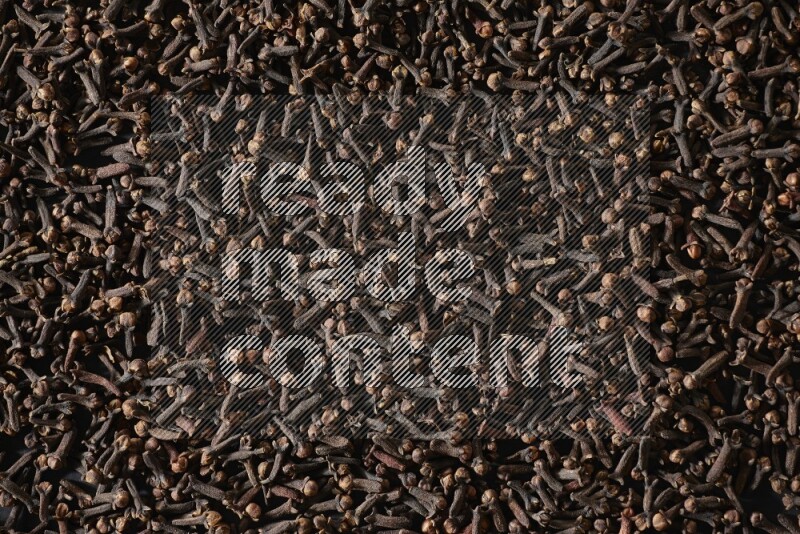 Cloves spread on black flooring