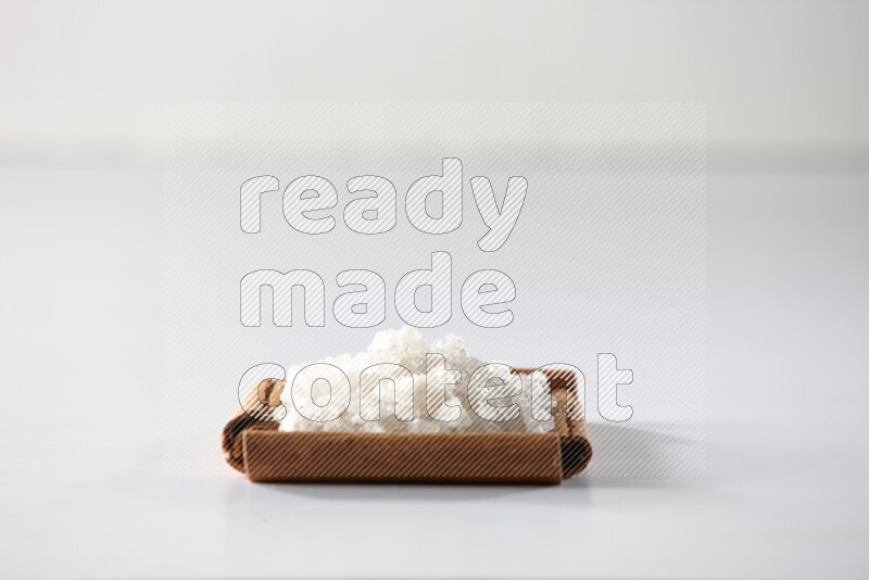 A single square of cinnamon sticks full of salt on white flooring
