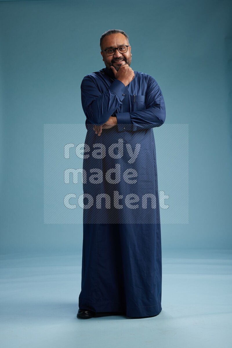 Saudi Man without shimag Standing Interacting with the camera on blue background