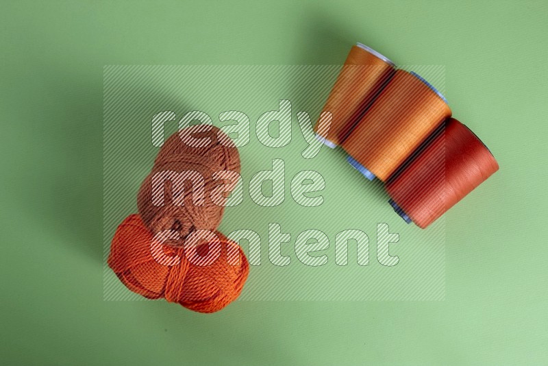 Orange sewing supplies on green background