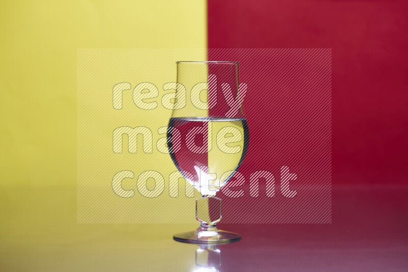 تظهر الصورة أواني زجاجية ممتلئة بالماء موضوعة على خلفية من اللونين الأصفر والأحمر