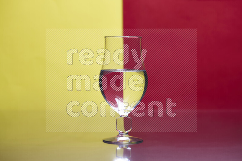 The image features a clear glassware filled with water, set against yellow and red background
