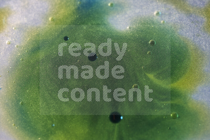 لقطات مقربة لقطرات ألوان مائية صفراء وزرقاء وخضراء على سطح الزيت على خلفية بيضاء