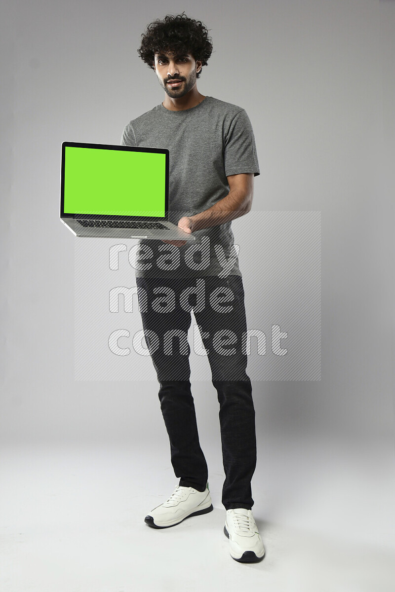 A man wearing casual standing and showing a laptop screen on white background