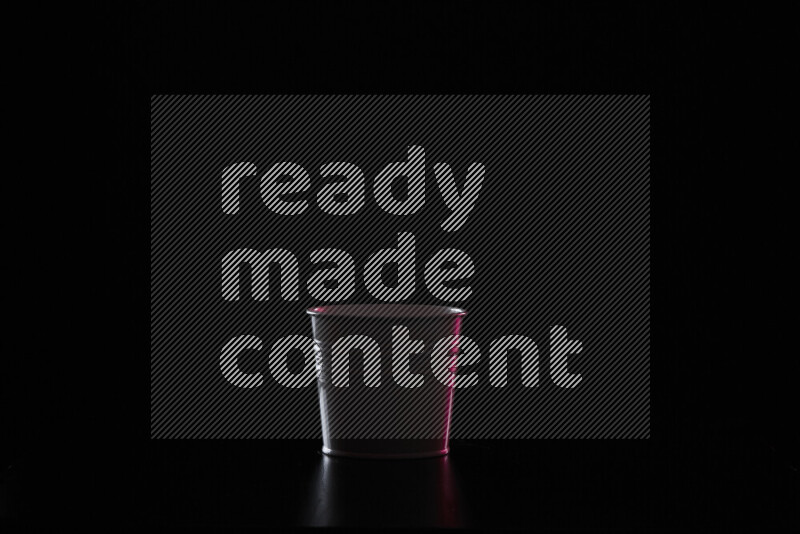 A plant pot with colored rim light against black background