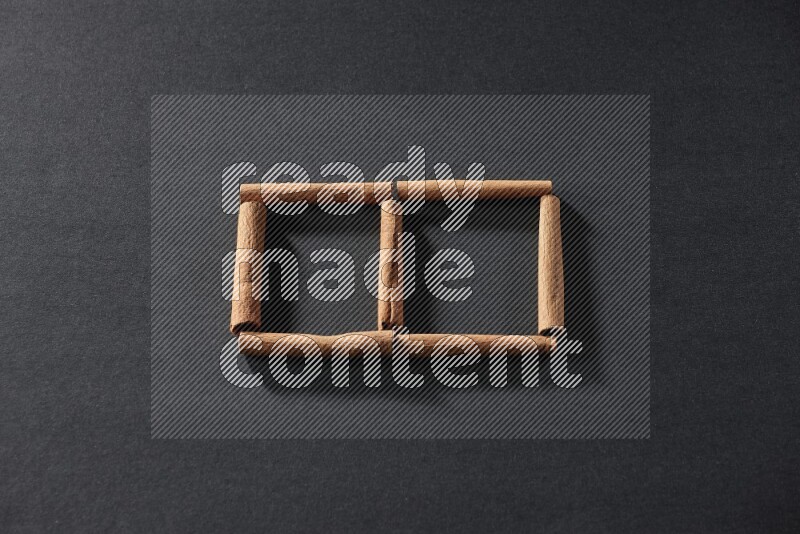 مربعان من أعواد القرفة فارغان علي خلفية سوداء