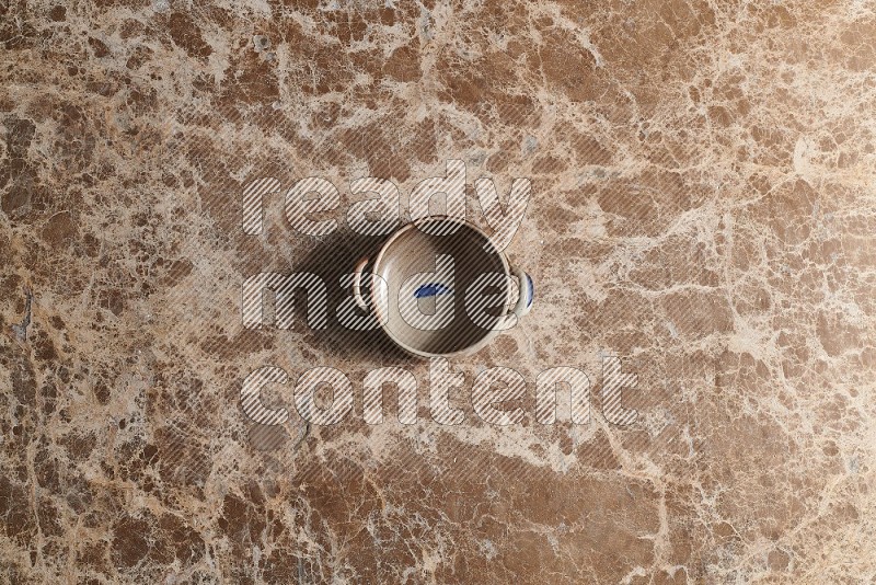 Top View Shot Of A Multicolored Pottery bowl On beige Marble Flooring