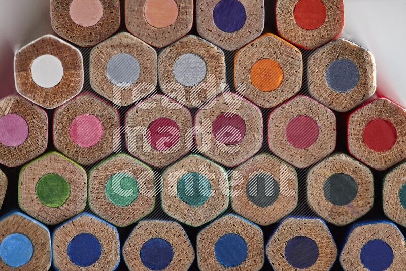 صورة مقربة لأطراف أقلام خشبية ملونة مرتبة في مجموعة علي خلفية بيضاء