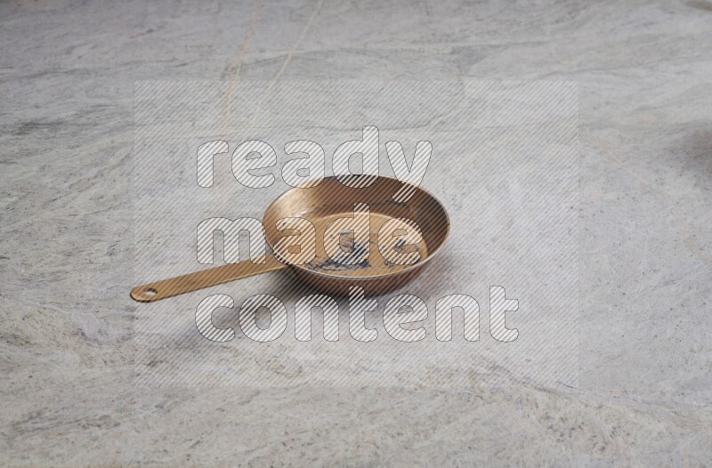 A small copper pan on grey marble background