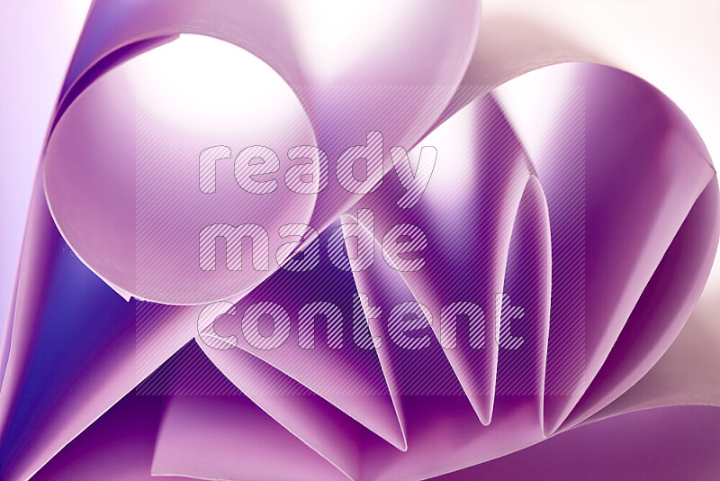 An artistic display of paper folds creating a harmonious blend of geometric shapes, highlighted by soft lighting in purple tones