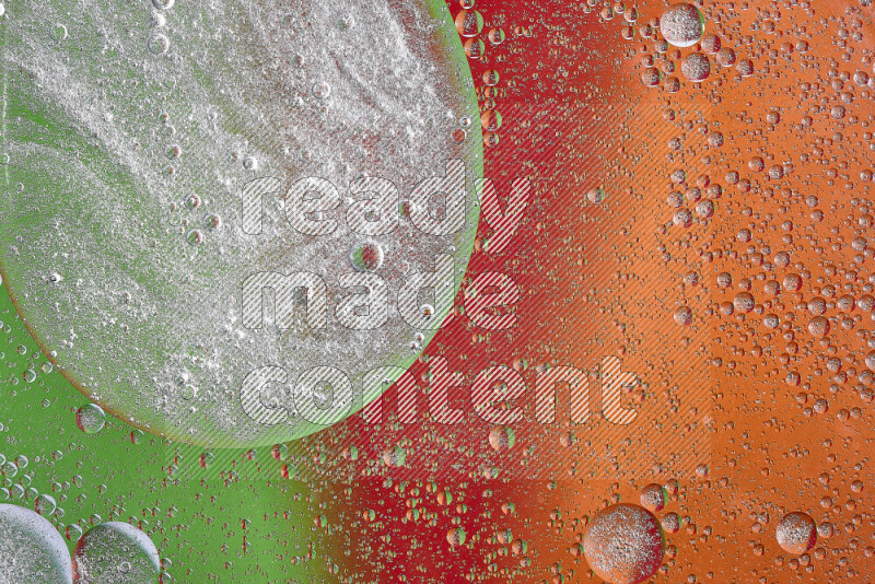 Close-ups of abstract oil bubbles on water surface in shades of orange, green and red