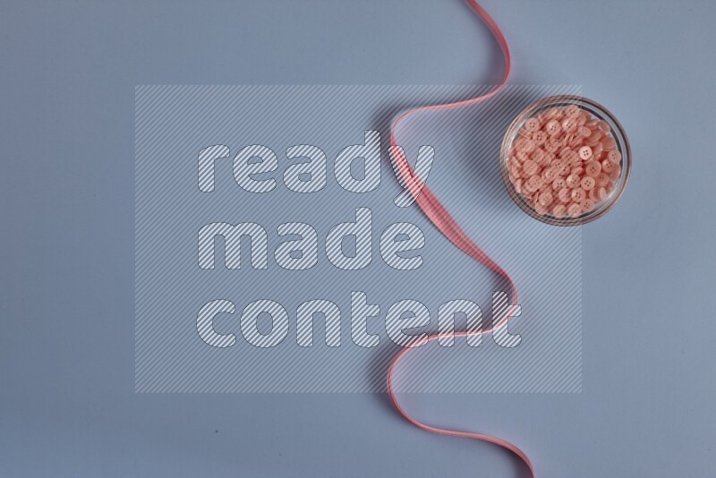 مجموعة من أدوات الخياطة والتفصيل زهرية اللون على خلفية زرقاء