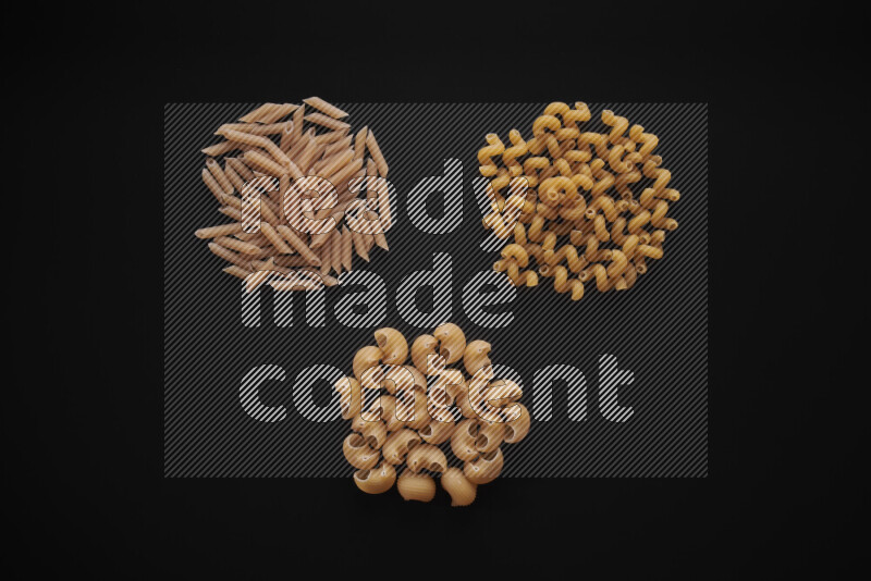 Different pasta types in bunches on black background
