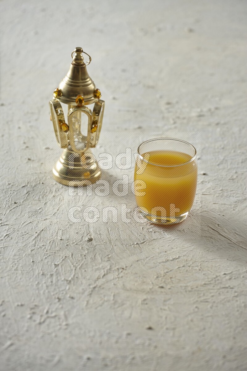 A golden lantern with different drinks, dates, nuts, prayer beads and quran on textured white background