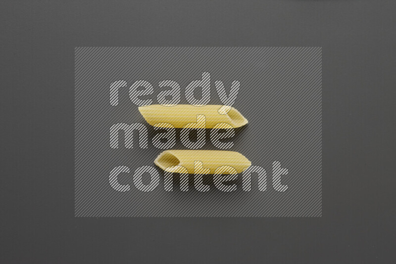 Penne pasta on grey background