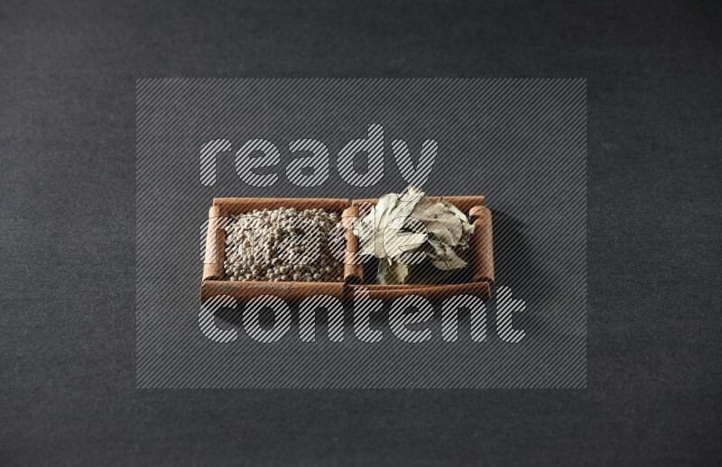 2 squares of cinnamon sticks full of white peppers and bay laurel leaves on black flooring
