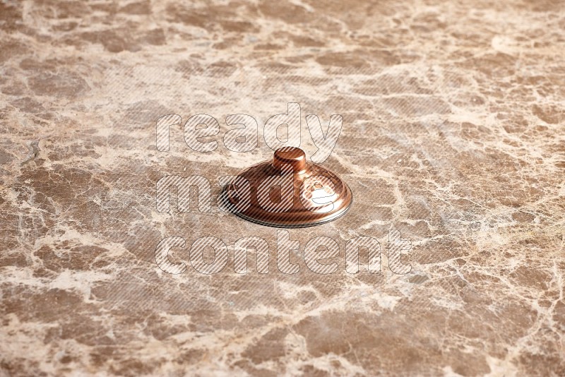 Small Copper Pot's Lid on Beige Marble Flooring